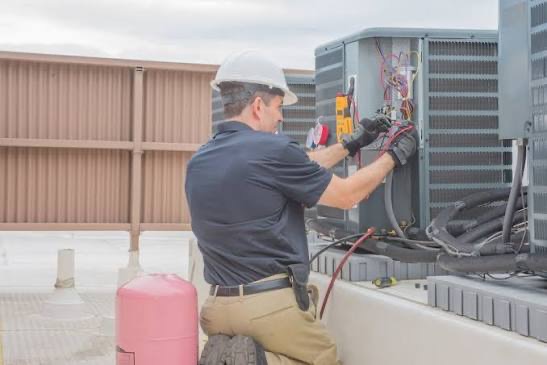 HVAC technician servicing commercial rooftop AC units
