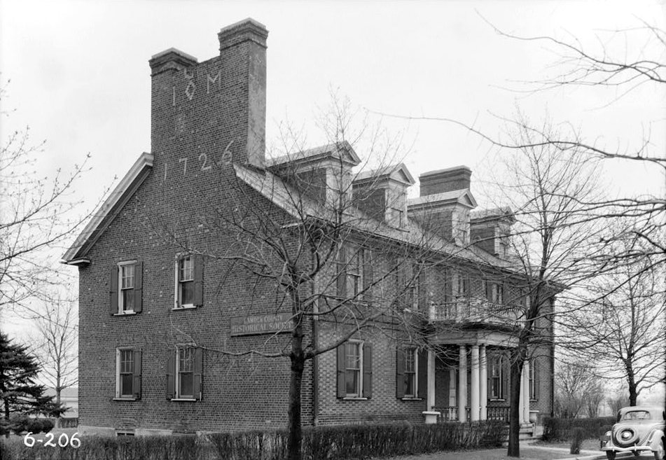 Black-and-white photograph of Pomona Hall, a two-story brick Georgian house in Camden with the date 1726 set into the chimney wall
