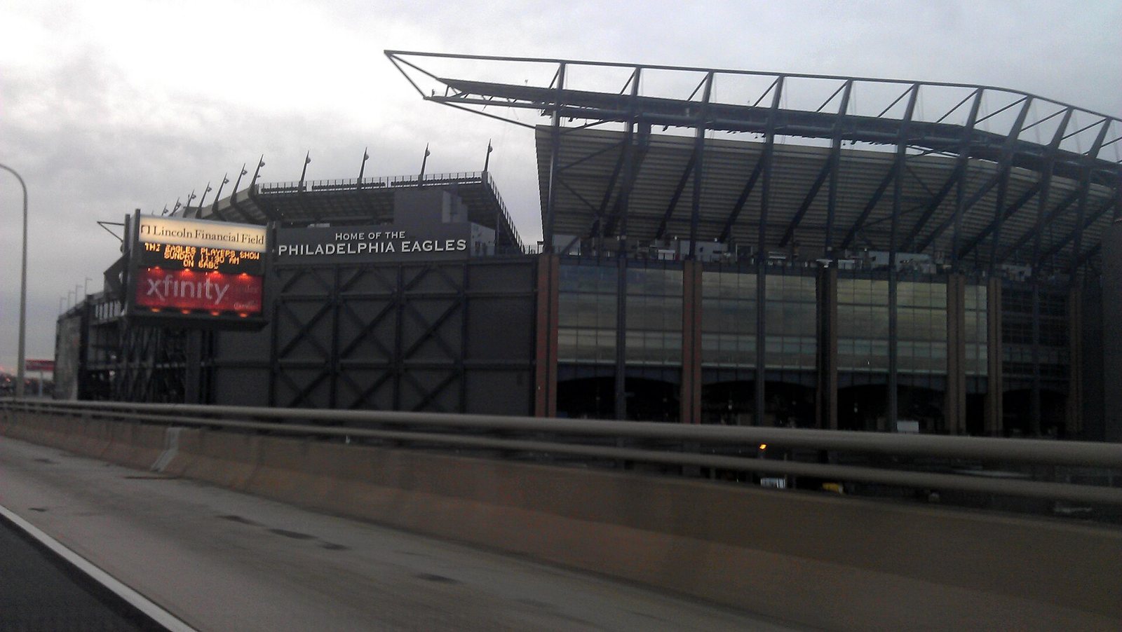 The outside of Lincoln Financial Field under a gray sky, with a sign reading Home of the Philadelphia Eagles