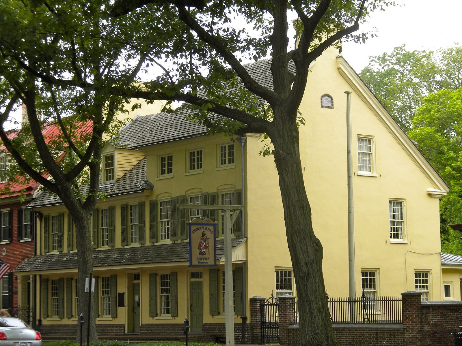The yellow Indian King Tavern building with its hanging tavern sign on Kings Highway in Haddonfield