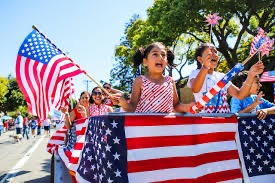 Kids waving American flags at a Fourth of July parade