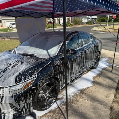 TCB Auto Detailing in action — mobile service in a South Jersey neighborhood — under American flag canopy