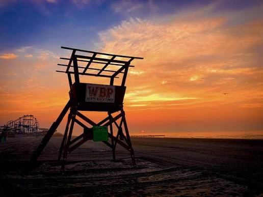 A Wildwood Beach Patrol stand silhouetted at sunset