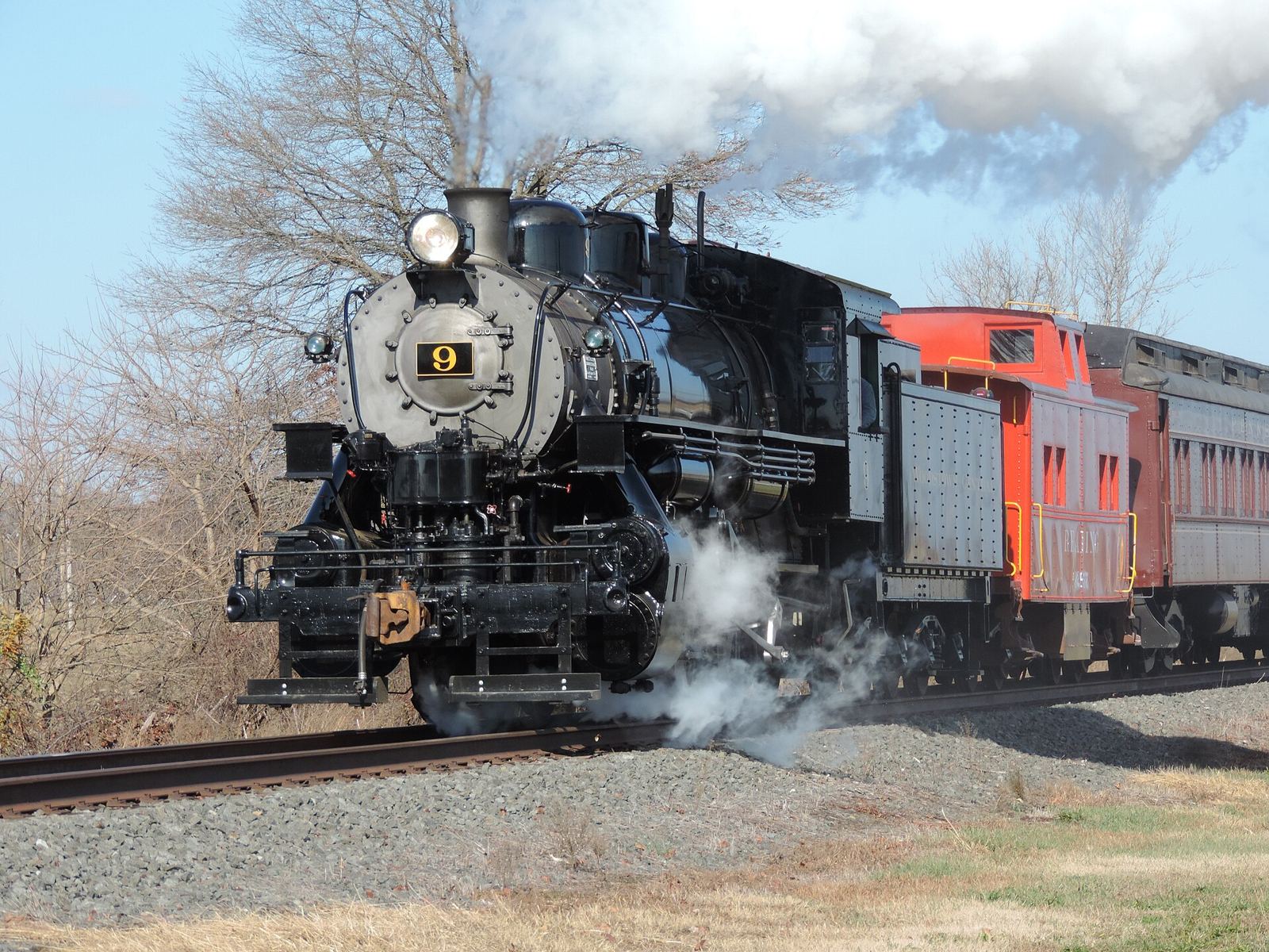 Woodstown Central steam locomotive No. 9 pulling a caboose and coach through the countryside